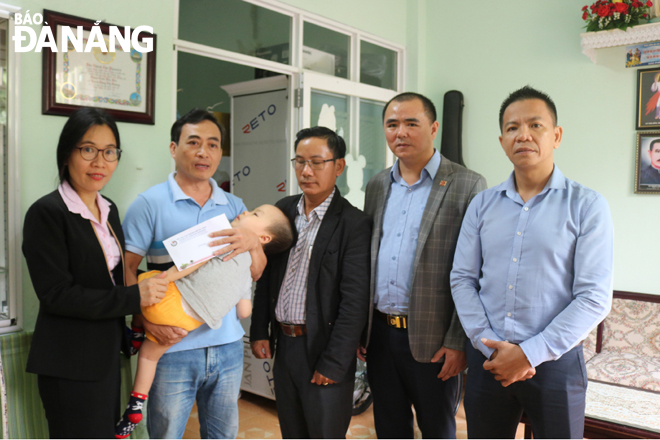 Đại diện chương trình “Ly cà-phê yêu thương” trao quà hỗ trợ cho gia đình cháu Trần Phúc Bảo Khang.
