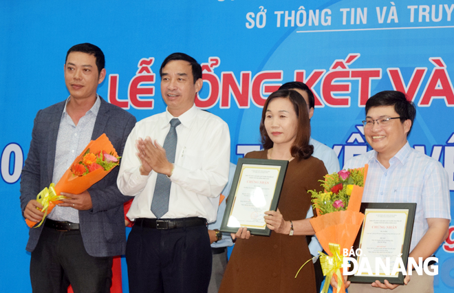 Phó Chủ tịch UBND thành phố Lê Trung Chinh (thứ 2 từ trái sang) trao giải nhất và nhì cho các tác giả có tác phẩm thuộc nhóm đề tài “Năm tiếp tục đẩy mạnh thu hút đầu tư”.
