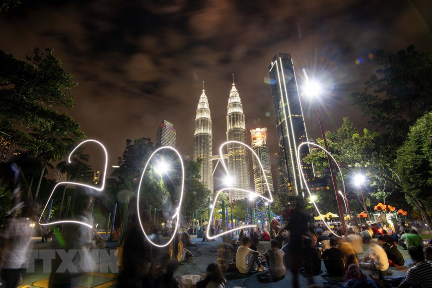 Người dân đón thời khắc giao thừa trong lễ hội năm mới ở tòa tháp đôi Petronas, Kuala Lumpur, Malaysia. (Ảnh: THX/TTXVN)