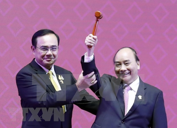 PM Nguyen Xuan Phuc receives the chairmanship gavel from his Thai counterpart Prayut Chan-o-cha at the closing ceremony of the 35th ASEAN Summit in Bangkok in November last year. (Photo: VNA)