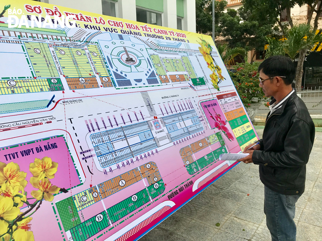 A flower trader learning about information on the Tet Flower Market 2020 at the city’s Green Trees-Park Company