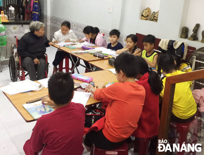 Chị Huỳnh Thị Xinh (ngồi xe lăn) dạy thêm tại nhà.