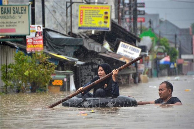 People take to paddling in small rubber lifeboats or tyre inner-tubes to get around in Indonesia (Photo: AFP/VNA)