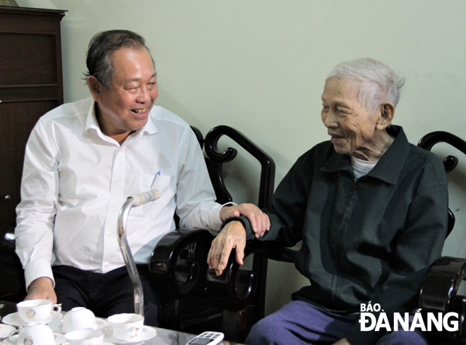 Deputy PM Truong Hoa Binh (left) extending his Tet wishes to former revolutionary veteran Tran Than