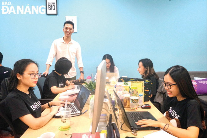 Anh Đinh Quang Huy (đứng) cùng đội ngũ dự án khởi nghiệp Botstar trong văn phòng ở đường Thái Phiên (quận Hải Châu).  Ảnh: KHANG NINH