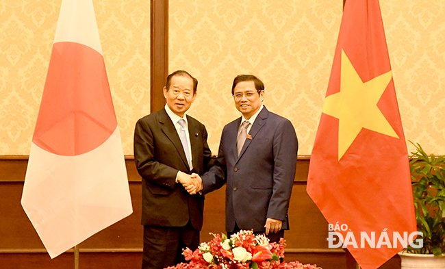 Head of the Organisation Commission of the Party Central Committee Pham Minh Chinh (right) and Secretary General Toshihiro Nikai