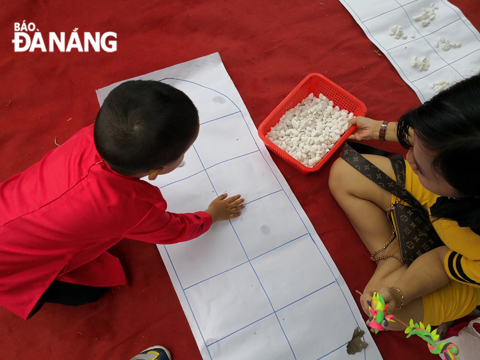 A boy playing ‘o an quan’ game (mandarin square capturing)