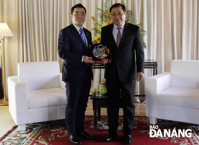Chủ tịch UBND thành phố Huỳnh Đức Thơ trao quà lưu niệm cho lãnh đạo tỉnh Shiga, Nhật Bản. Ảnh: KHANG NINH