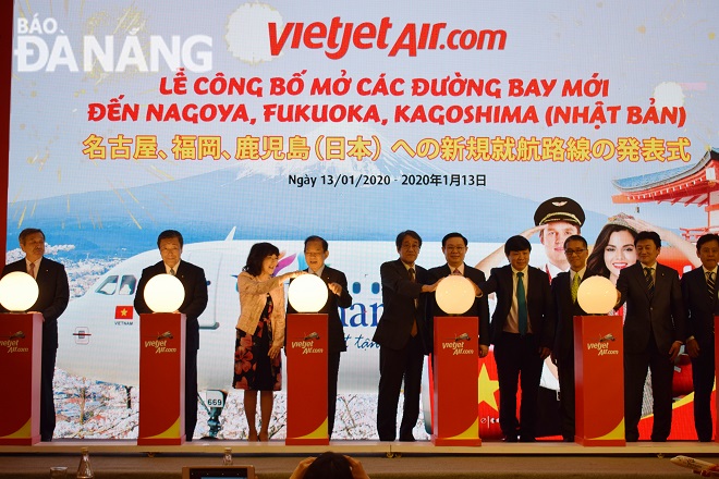 Deputy PM Hue (6th left) and delegates pressing buttons to announce new Vietjet Air-operated air routes between Viet Nam and Japan