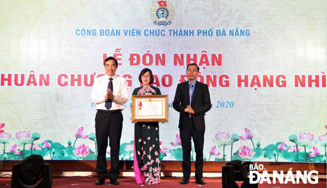 Phó Chủ tịch UBND thành phố Lê Trung Chinh (trái) trao Huân chương Lao động hạng Nhì cho Công đoàn Viên chức thành phố. Ảnh: LAM PHƯƠNG