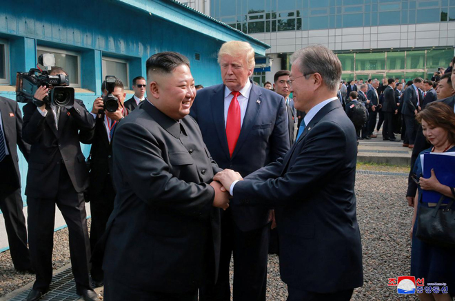 Nhà lãnh đạo Triều Tiên Kim Jong-un (trái) bắt tay thân mật với Tổng thống Hàn Quốc Moon Jae-in trong sự chứng kiến của Tổng thống Mỹ Donald Trump (giữa) ở khu vực biên giới liên Triều ngày 30-6-2019. Ảnh: Reuters
