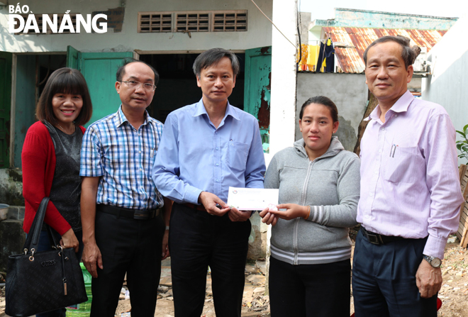 Representatives from the ‘Ly Ca Phe Yeu Thuong’ (Cup of Compassion Coffee) programme giving a Tet cash gift to Mrs Trang (2nd right)