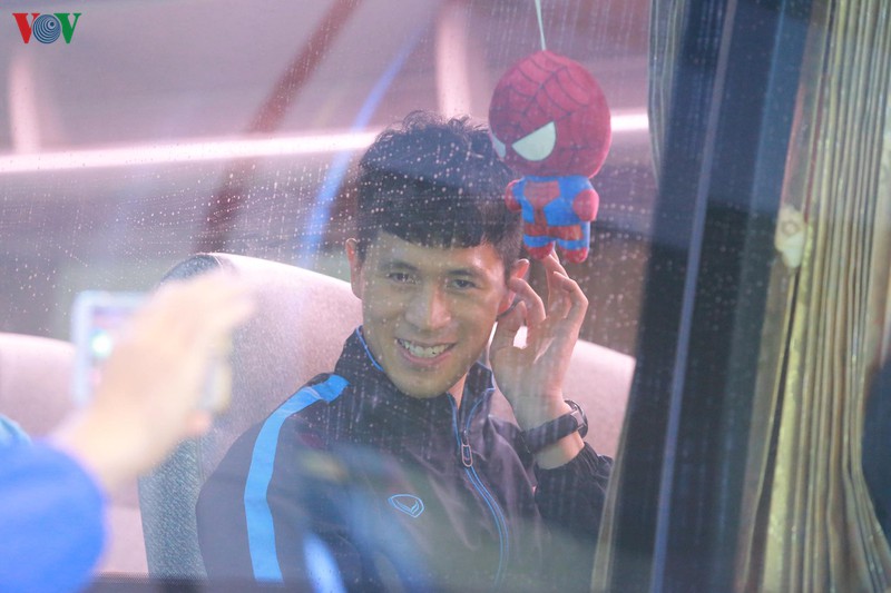 Trung vệ Trần Đình Trọng tươi cười với người hâm mộ trước khi xe bus chở U23 Việt Nam rời sân bay Nội Bài về khách sạn.