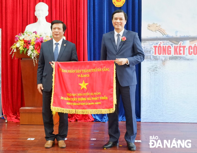 Phó Chủ tịch UBND thành phố Trần Văn Miên trao tặng Cờ thi đua 30 năm xây dựng và phát triển cho Kho bạc Nhà nước Đà Nẵng.  Ảnh: Mai Quế