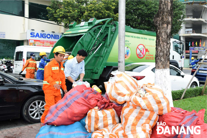 Công nhân Công ty CP Môi trường đô thị Đà Nẵng thu gom rác tại quận Hải Châu. Ảnh: HOÀNG HIỆP