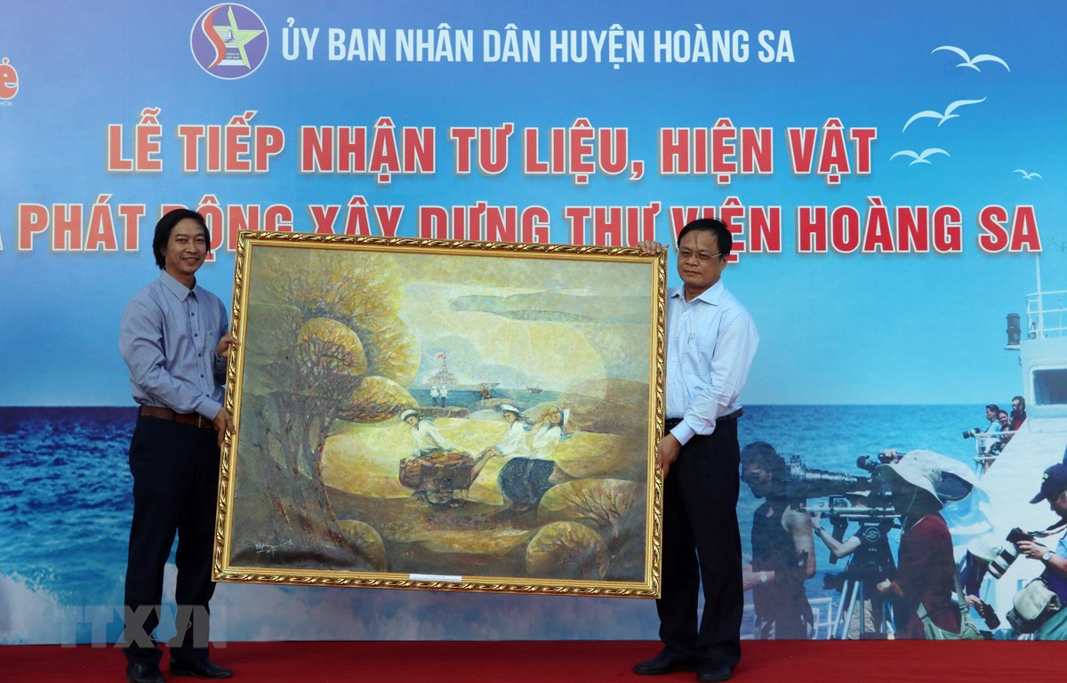 Chairman of the Hoang Sa (Paracel) Islands District People’s Committee Vo Ngoc Dong (right) receiving a painting from a local painter