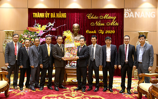 Mục sư Nguyễn Quang Đức (thứ 5 từ trái sang) tặng quà và chúc mừng năm mới lãnh đạo thành phố. Ảnh: ĐẶNG NỞ