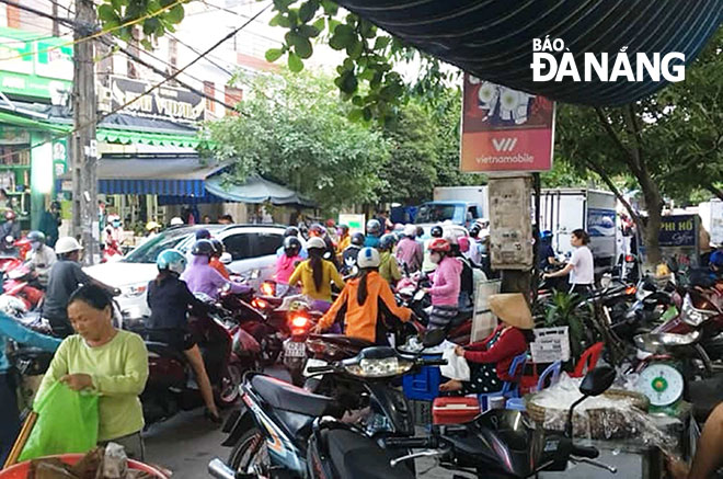 Tình trạng dựng xe mua bán dưới lòng đường thường xuyên xuất hiện tại các chợ trên địa bàn Đà Nẵng. Ảnh: HUỲNH LÊ  