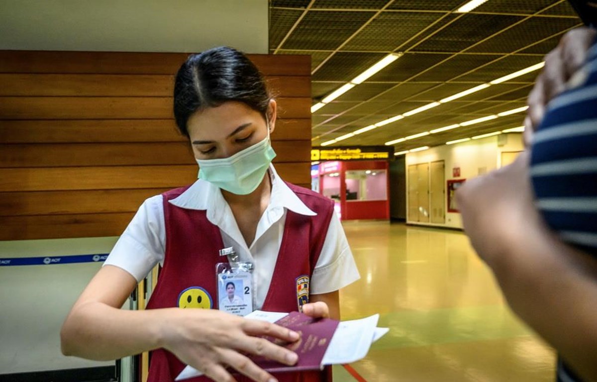 Trong ảnh: Nhân viên kiểm tra hộ chiếu của một hành khách tại sân bay Don Mueang ở Bangkok, Thái Lan ngày 21-1-2020. (Ảnh: AFP/TTXVN)