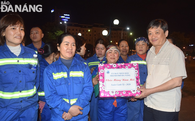 Phó Chủ tịch Thường trực UBND thành phố Đặng Việt Dũng (bìa phải) tặng quà cho công nhân vệ sinh môi trường thực hiện nhiệm vụ trong đêm giao thừa.