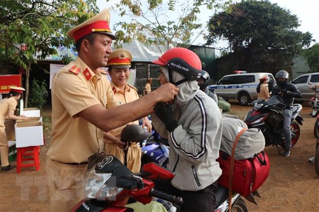 Cảnh sát giao thông Đắk Nông tuyên truyền pháp luật về trật tự an toàn giao thông, đồng thời đổi mũ bảo hiểm đạt chuẩn cho người dân. (Ảnh: TTXVN phát)