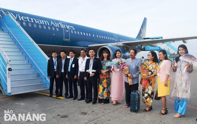 Lãnh đạo Sở Du lịch thành phố và Vietnam Airlines chào đón những vị khách đầu tiên xông đất Đà Nẵng tại cầu thang máy bay.