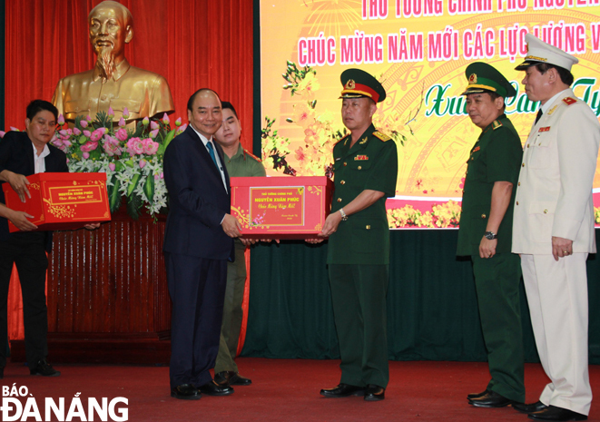 PM Phuc (left) presenting Tet gifts to representatives from the city-based armed forces on the first day of the lunar new year