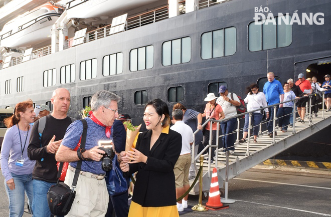 Representatives from the Tourism Department presenting flowers to the first cruise ship passengers to set foot in the city on the second day of the Lunar New Year.