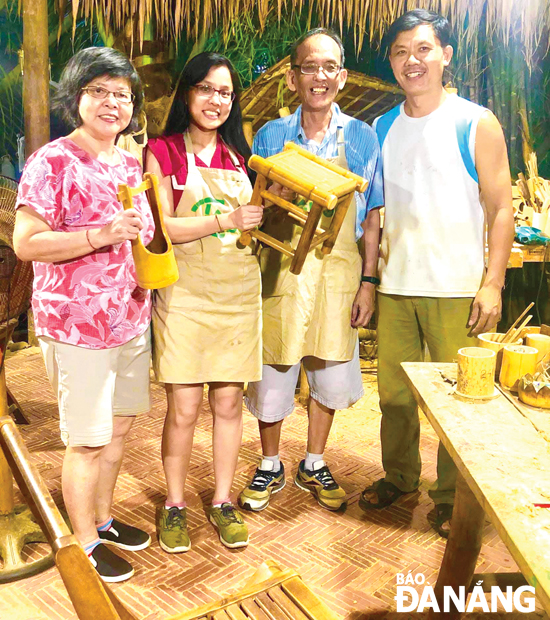 Vo Tan Tan (right) and Singaporean visitors at his Taboo Bamboo shop