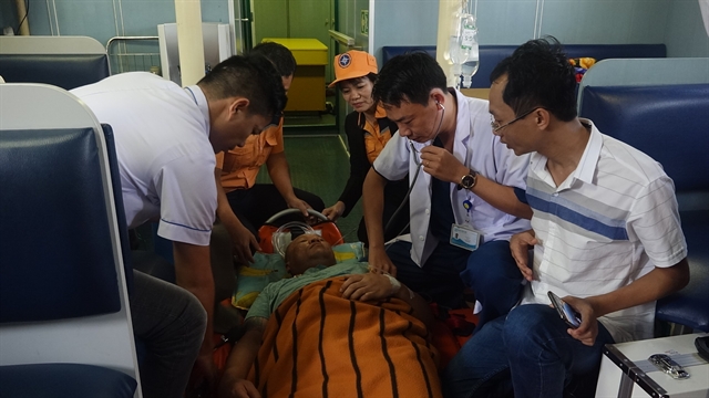 Rescue workers and doctors from Da Nang-based Maritime Co-ordination and Rescue Centre No2 give first aid to a sailor on a Thai cargo ship off the coast of Da Nang on January 26. Photo courtesy MRCC2