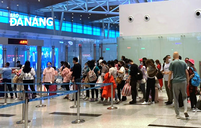 Đoàn du khách làm thủ tục lên máy bay tại Sân bay quốc tế Đà Nẵng tối 27-1. Ảnh: ĐÌNH ĐÔNG