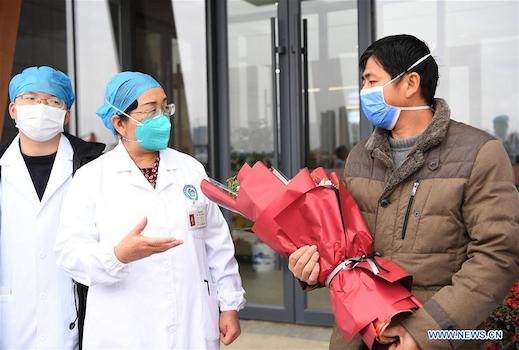 Bác sĩ chữa trị tặng hoa cho bệnh nhân. Ảnh: News.cn