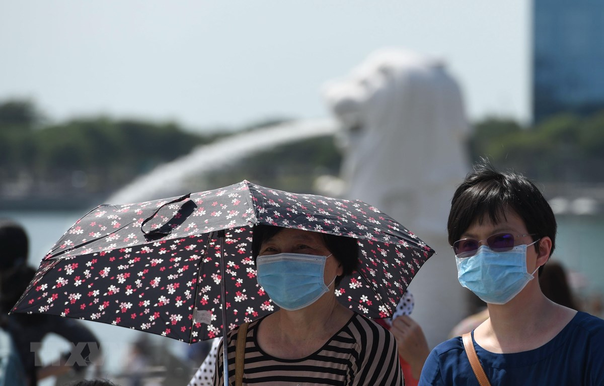 Người dân đeo khẩu trang để phòng tránh lây nhiễm virus corona tại Singapore. (Ảnh: AFP/TTXVN)