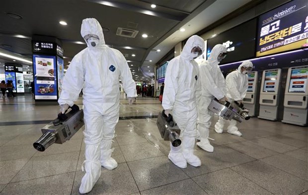 Nhân viên y tế khử trùng tại bến xe buýt ở Gwangju, Hàn Quốc nhằm ngăn chặn sự lây lan của virus n-CoV. (Ảnh: AFP/TTXVN)