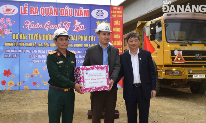 Phó Chủ tịch Thường trực UBND thành phố Đặng Việt Dũng (bìa phải) tặng quà tết cho đại diện các nhà thầu thi công tuyến đường vành đai phía tây. Ảnh: HOÀNG HIỆP