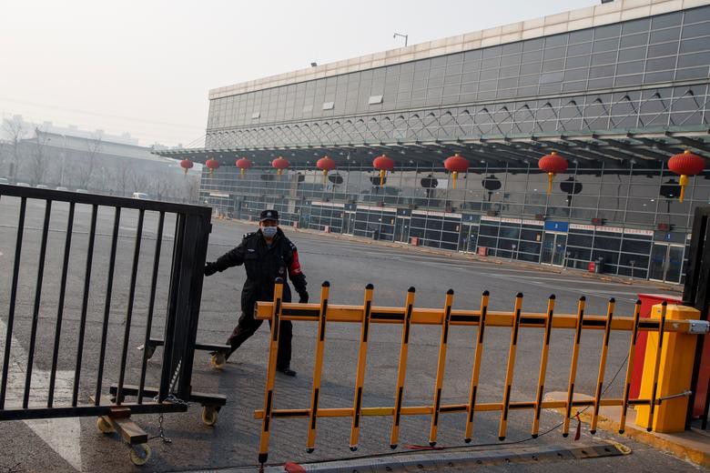 Nhân viên bảo vệ đang đóng cổng tại trạm xe buýt đường dài Sihui ở Bắc Kinh, sau khi thành phố Bắc Kinh tạm ngừng dịch vụ xe buýt liên tỉnh ngày 26/1.