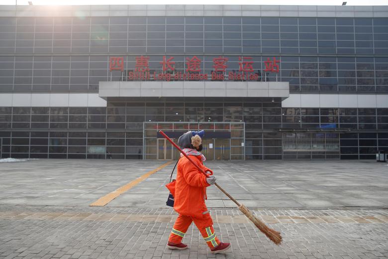 Nhân viên quét dọn đi ngang qua Trạm xe buýt đường dài Sihui ở Bắc Kinh, ngày 26/1.