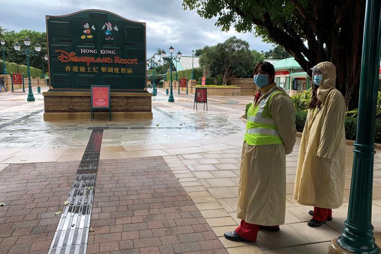 Các nhân viên đeo khẩu trang bảo hộ đứng bên ngoài công viên giải trí Disneyland Hong Kong. Công viên này đã bị đóng cửa nhằm ngăn chặn virus corona lây lan.