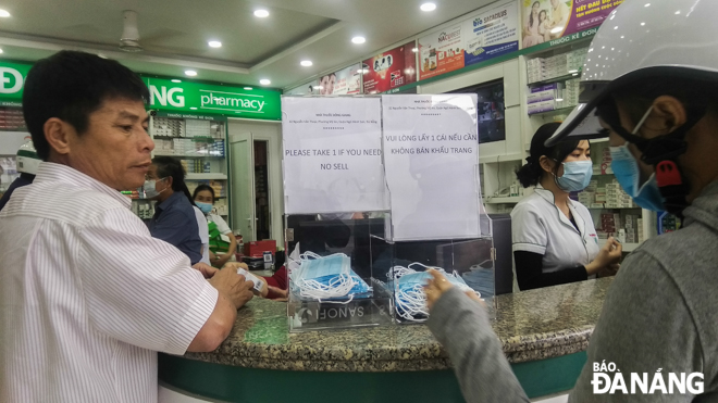 Two plastic boxes of free face masks at the Dong Giang Pharmacy