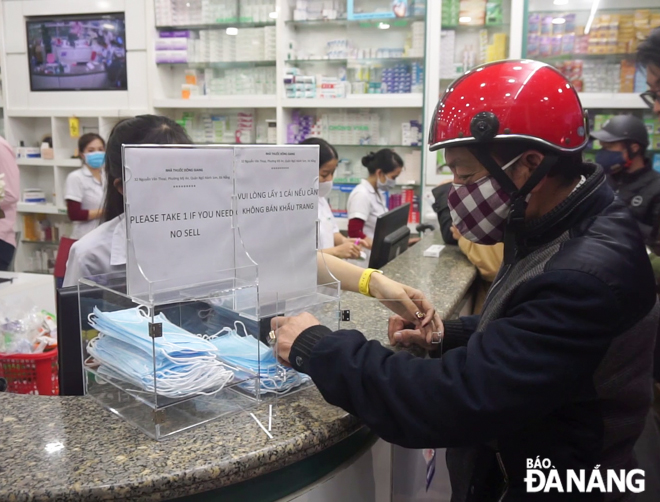 Người dân nhận khẩu trang tại hiệu thuốc trên đường Nguyễn Văn Thoại. Ảnh: TRƯỜNG KỲ