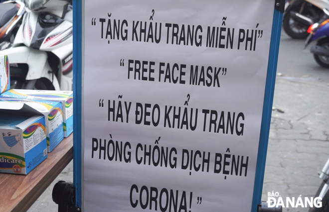 A signboard about free face masks in front of a milk tea shop on Hoang Hoa Tham Street