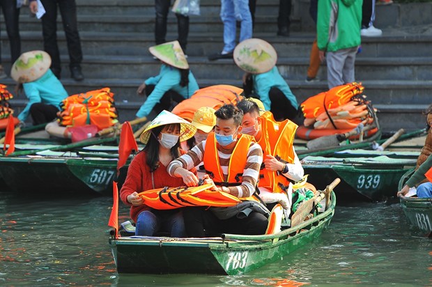 Tourists wear face masks while visiting the Trang An Landscape Complex in Ninh Binh province (Photo: VNA)