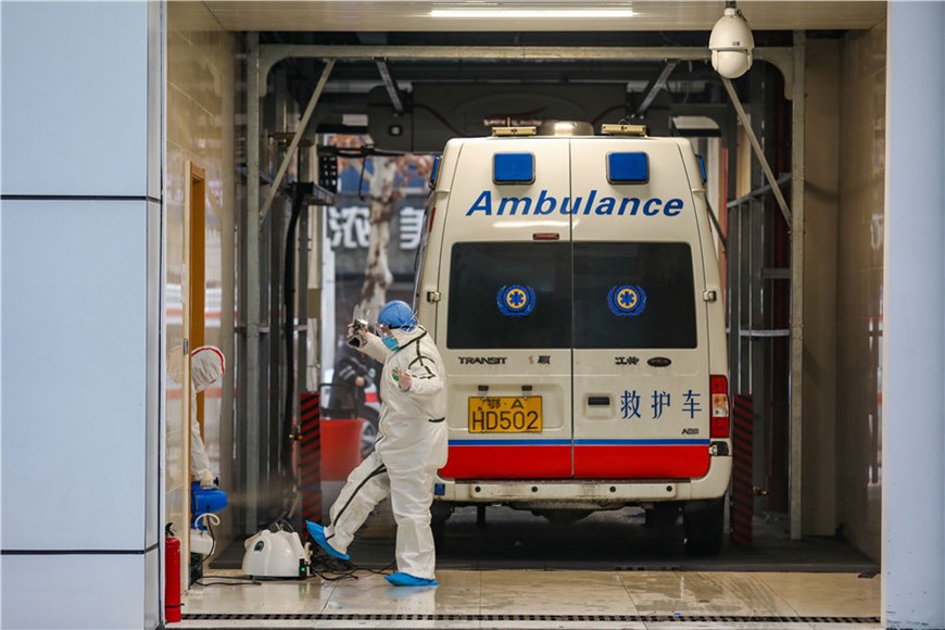 Nhân viên y tế khử trùng xe cấp cứu và bản thân mình sau một ngày làm việc vất vả. (Nguồn: chinadaily.com.cn)