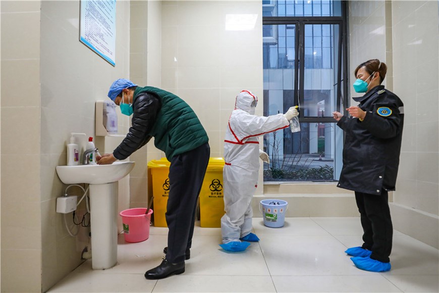 Các nhân viên y tế đang khử trùng cho nhau. (Nguồn: chinadaily.com.cn)
