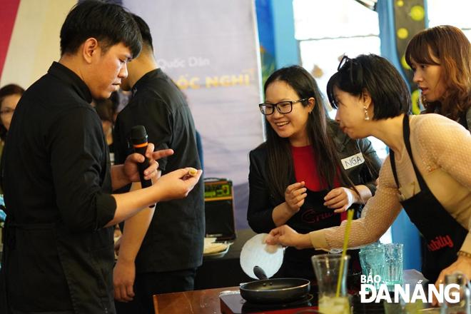 Anh Nguyễn Quốc Nghị (ngoài cùng bên trái) hướng dẫn cách làm một số món ăn thuần Việt cho học viên.   Ảnh: KHANG NINH