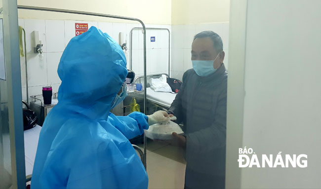  Nhân viên y tế Bệnh viện Phổi Đà Nẵng mang thức ăn hàng ngày cho bệnh nhân trong khu vực cách ly.Ảnh: PHAN CHUNG
