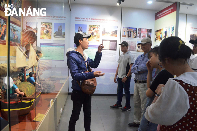 Du khách tham quan, tìm hiểu về lịch sử biển, đảo của Việt Nam tại Nhà Trưng bày Hoàng Sa.  Trong ảnh: Hướng dẫn viên đang thuyết minh về các hiện vật trưng bày cho du khách.      Ảnh: THU HÀ