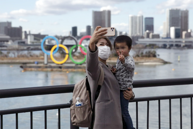 Du khách chụp ảnh trước biểu tượng Olympic ở Tokyo.