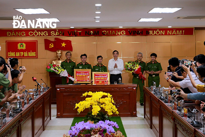 Ơhó Chủ tịch UBND thành phố Lê Trung Chinh trao thưởng 100 triệu đồng cho Công an thành phố. Ảnh: NGỌC PHÚ