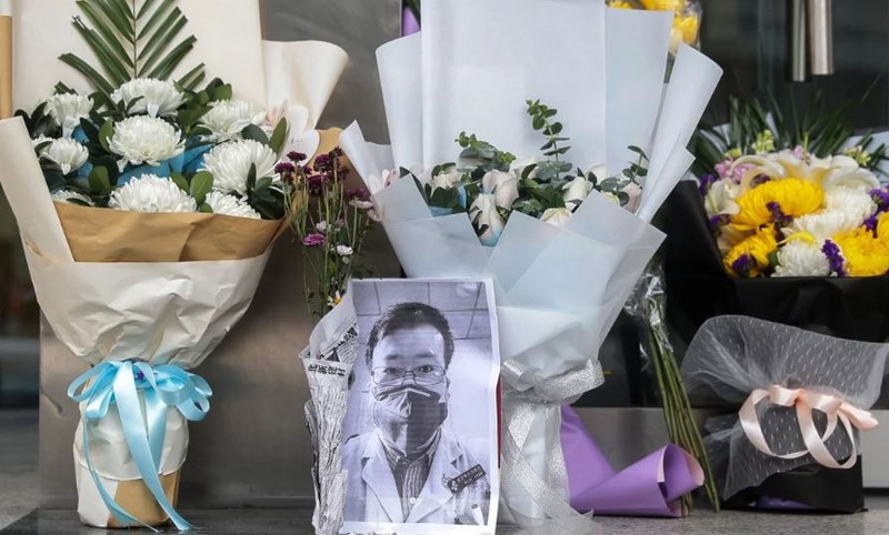 Nhiều người đã tới Bệnh viện Trung tâm Vũ Hán - nơi bác sĩ Lý Văn Lượng từng làm việc đặt hoa và những bức ảnh đen trắng của anh trước lối vào bệnh viện để tưởng nhớ anh. Ảnh: EPA